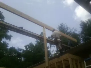 Carpenter setting a ridge beam over a new addition frame — Ice Dam Removal by Roofing Brothers in Newbury Park