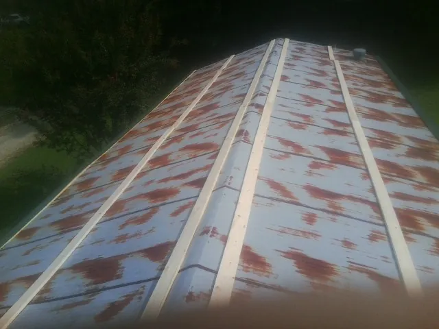 Rusted metal roof panels with new wood purlins before replacement — Storm Damage Roof Repair in Newbury Park by Roofing Brothers