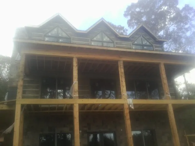 Dormers and porch framing on a large log home under construction — Roof Coating work by our crew in Newbury Park