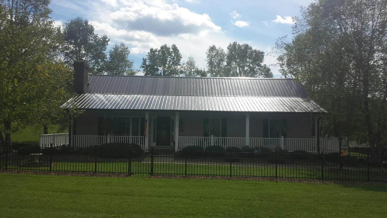 Gray metal roof on a brick ranch with a full width front porch — Gutter Guard Installation work by our crew in Newbury Park