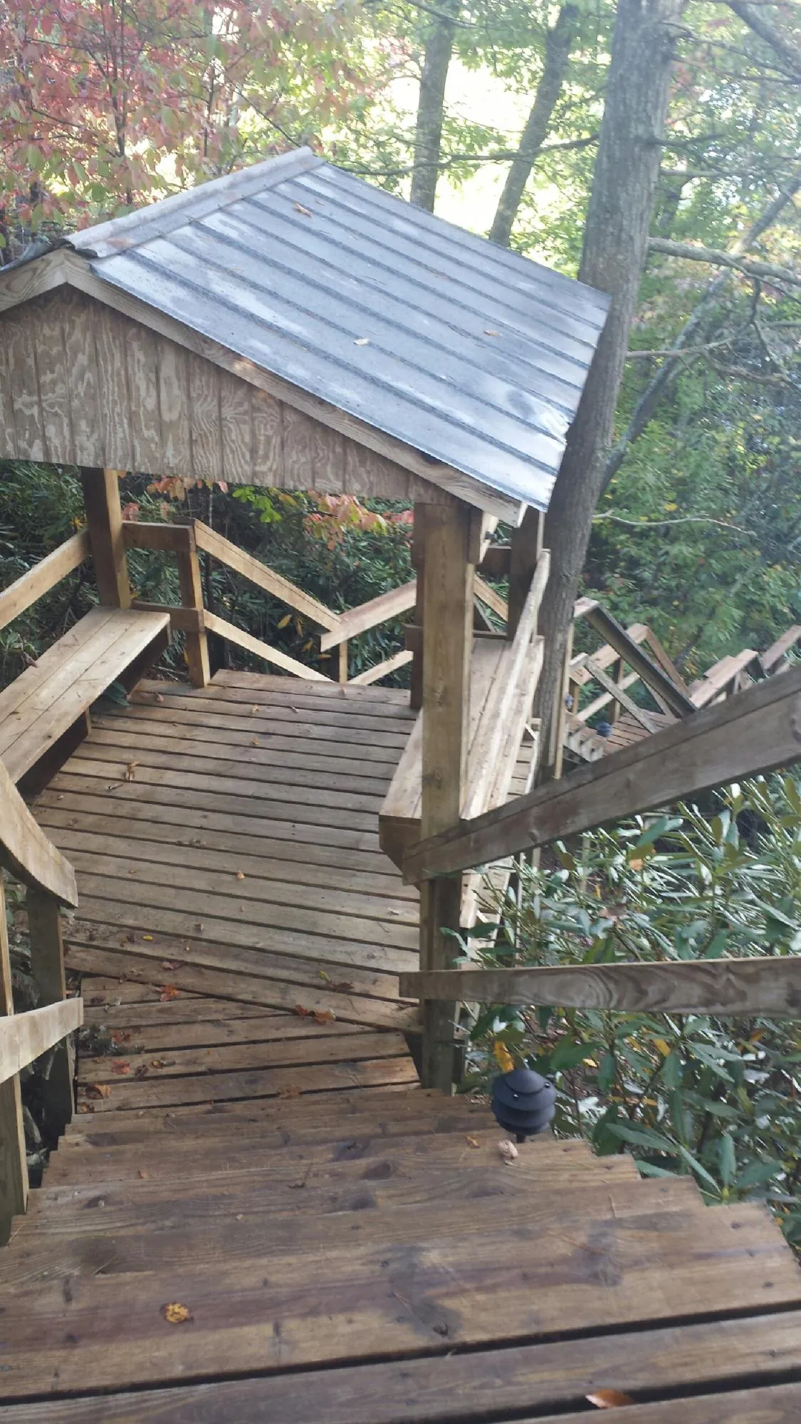 Metal roofed shelter over wooden steps on a wooded walkway — Skylight Repair & Installation work by our crew in Newbury Park